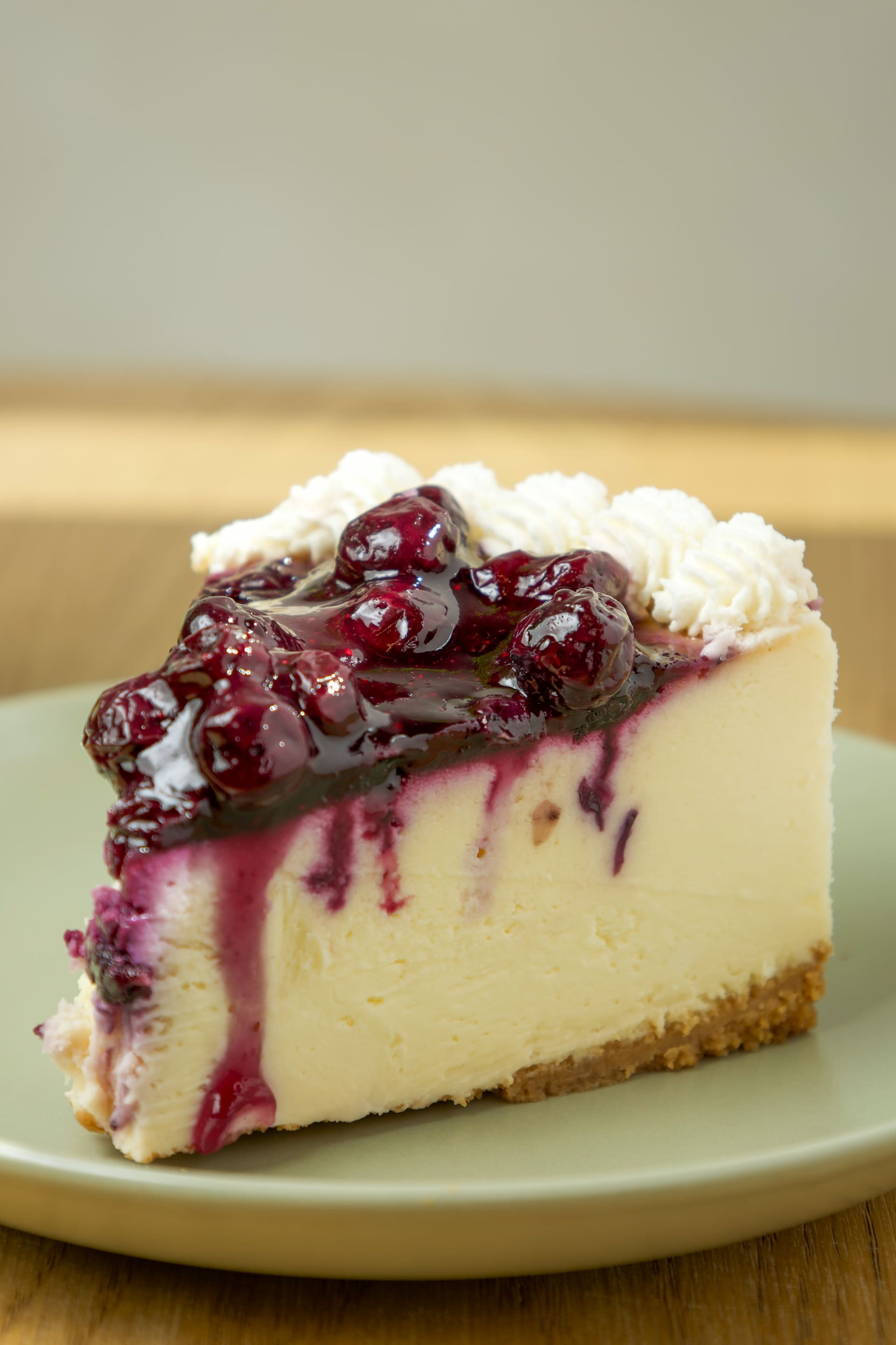 Porción de cheesecake con salsa de arándanos.